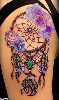 the back of a woman's shoulder with flowers and a dream catcher on it