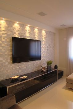 a large flat screen tv mounted to the side of a wall in a living room