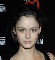 a close up of a person with a necklace on her neck and wearing a black top