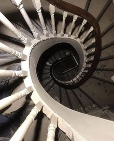 the inside of a spiral staircase with white railings