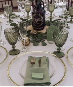 the table is set with place settings and wine bottle