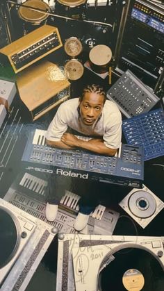 a man is surrounded by various musical equipment