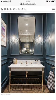 a bathroom with blue walls and gold fixtures on the vanity, along with a large mirror