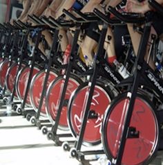 many people are riding stationary bikes in a row