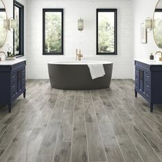 a large bathroom with two sinks and a bathtub in the middle of the room