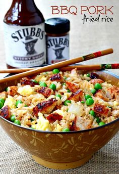 a bowl filled with rice, peas and meat next to two bottles of bbq pork fried rice