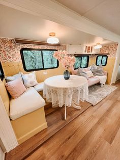 a living room filled with furniture and flowers on top of a wooden flooring area