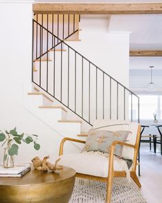 a living room filled with furniture and a stair case next to a table on top of a rug