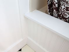 the corner of a white bathroom with black and white tile