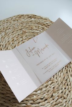 an open wedding card on top of a wicker basket