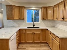 a kitchen with wooden cabinets and white counter tops