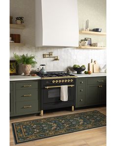 a stove top oven sitting inside of a kitchen next to a rug on the floor