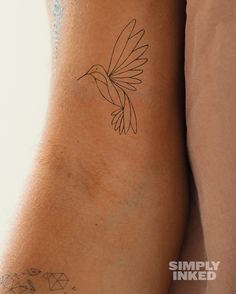 a bird tattoo on the back of a woman's left arm and leg,