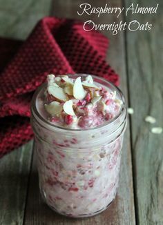 a jar filled with food sitting on top of a wooden table next to a red towel