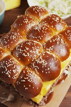 a hot dog bun covered in cheese and sesame seeds