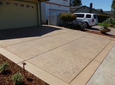 a white truck is parked in front of a house with driveway and landscaping around it