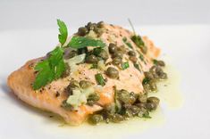 a white plate topped with salmon and capers