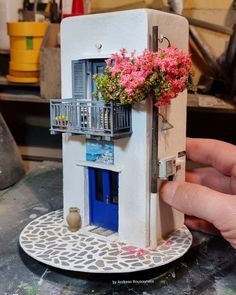 a miniature house with flowers growing out of it