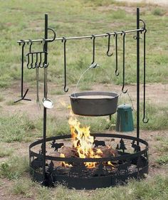 an outdoor fire pit with cooking utensils hanging from it's sides and on the outside