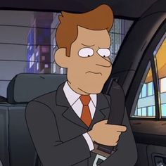 a man in a suit and tie holding a cell phone while sitting in a car