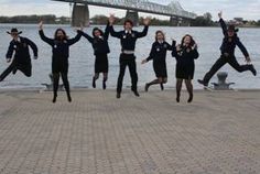 a group of people jumping in the air with their arms up and legs spread out