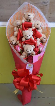 a bouquet of teddy bears wrapped in red ribbon