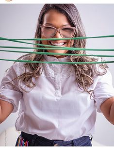 a woman wearing glasses is holding green sticks