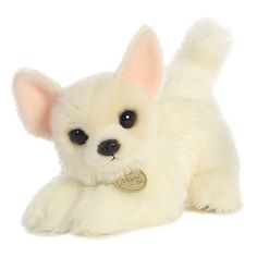 a small white stuffed dog with a tag on it's collar and ears is laying down