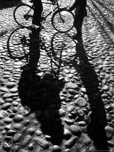 two people standing next to each other with their bikes