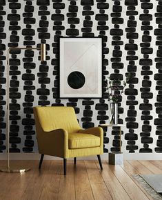 a yellow chair sitting in front of a black and white wall