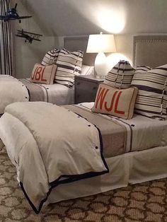 two beds in a room with pillows and lamps on the nightstands next to each other