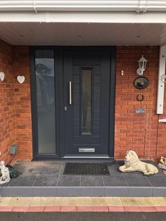 the front entrance to a house with two lions statues on the steps and a black door