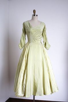 "Incredibly unique and gorgeous green party dress from the 1950s. This dress features the coolest asymmetrical bust details I've seen on a 50s dress! Then it also has these cool ruched dolman sleeves, a fitted waistline, a full skirt with striped green panels over the sides! It's just so special . Label: by Marigold No Houser . Measurements: { xsmall } Bust: 34\" Waist: 24\" Hips: open Length: 48\" Sleeve Length: 18\" . Condition: nearly excellent vintage condition with minor signs of wear - fai 1930s Green Dress, Green Ruched Dress With Fitted Bodice, Fitted Green Vintage Party Dress, Fitted Green Vintage Dress For Party, Retro Green Evening Dress, Green Retro Evening Dress, Green Retro Cocktail Dress, 1950s Style Green Evening Dress, Green 1950s Style Evening Dress