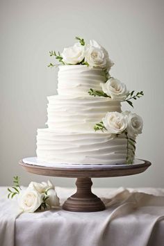 a white wedding cake with flowers on top