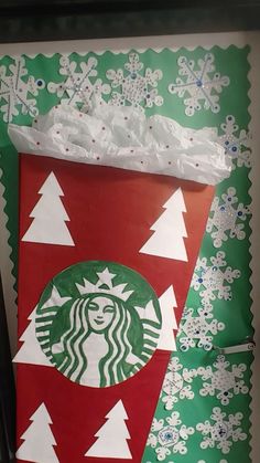 a starbucks bag is decorated with snowflakes and christmas tree decorations on green paper