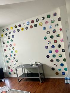 a living room filled with furniture and lots of magnets on the wall behind a table