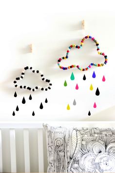 three raindrops hanging on the wall next to a crib with a baby's bed