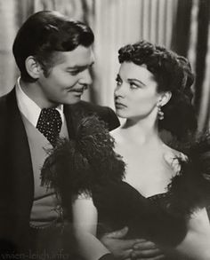 an old black and white photo of a man in a tuxedo next to a woman