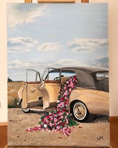 a painting of an old car with flowers on the front and side, sitting on a wooden easel