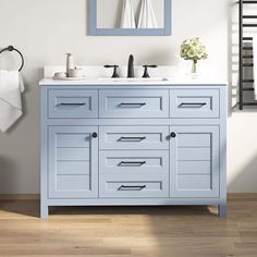 a bathroom vanity with two sinks and a mirror on the wall next to a towel rack