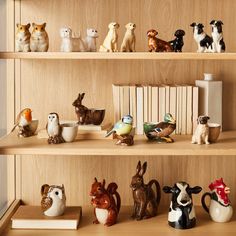 many small figurines are sitting on the shelves in front of bookshelves