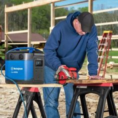 a man working on a piece of wood with a circular saw and power tool in front of him