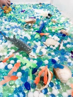 there are many different types of toys in the bathtub with bubbles and sea animals