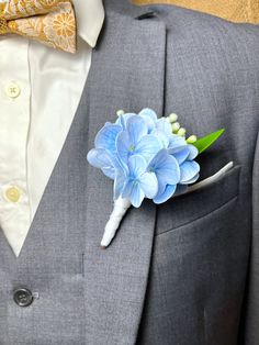 a boutonniere with blue flowers on the lapel of a man's suit