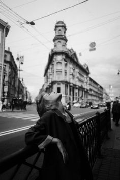 black and white photograph of woman looking up at building