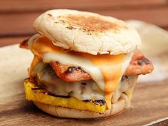 a grilled cheese and egg sandwich sitting on top of a wooden cutting board