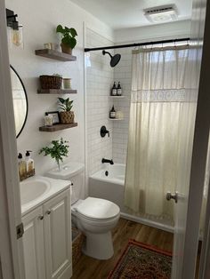 a bathroom with a toilet, sink and shower