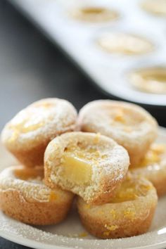 a white plate topped with donuts covered in powdered sugar and lemon zest