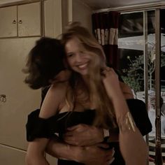 two women hugging each other in the kitchen