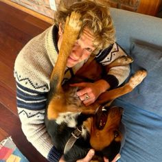 a woman sitting on a couch with two dogs